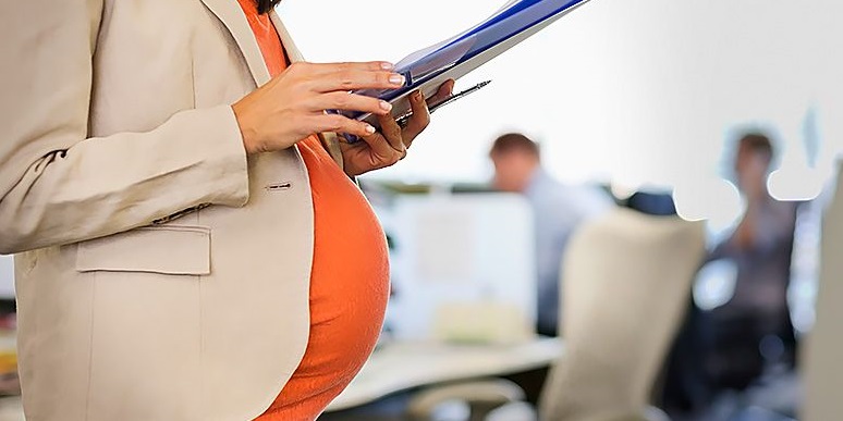 Pregnant person holding files