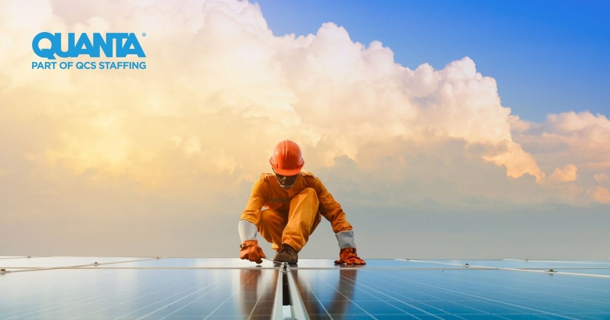 solar engineer standing on solar panels with clouds in the background