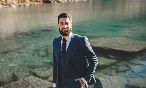 A picture of Sherif standing in front of a crystal clear pond