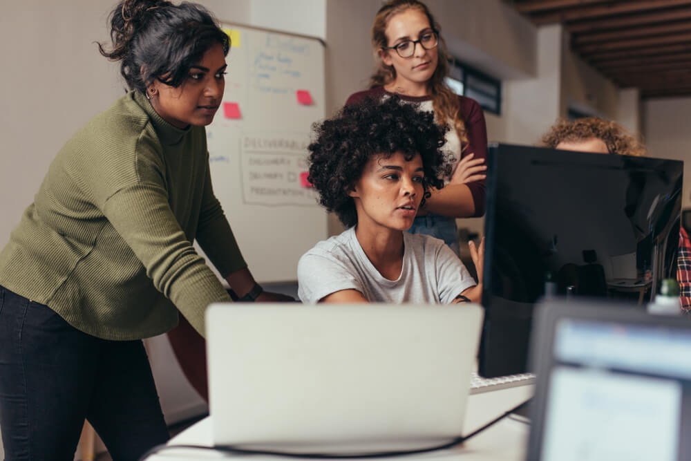 image of a team looking at a laptop