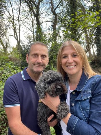 Alex alongside her partner and dog smiling towards the camera