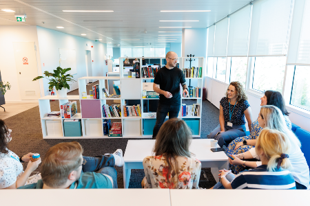 Photo of a team discussion on the sofas in the Romania office