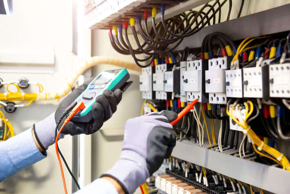 person testing an electrical board