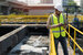 wastewater modeling professional on site wearing high-visibility jacket and helmet holding clipboard