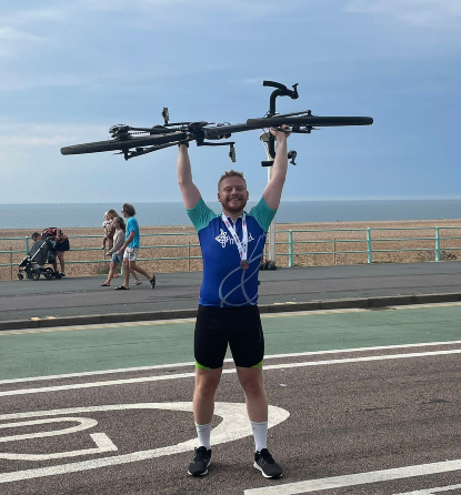 Photo of Dan lifting a bicycle