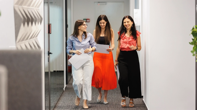 Picture of three women walking in the Romania office