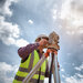 A surveyor wearing a high vis jacket and a hard hat