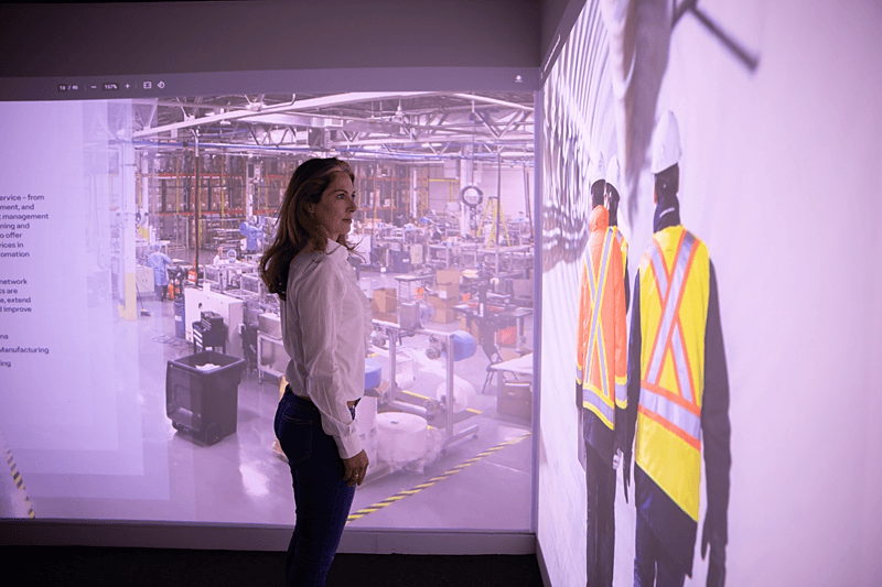 employee standing next to engineering visuals