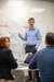 engineer standing against a board with detialed plans pinned to it