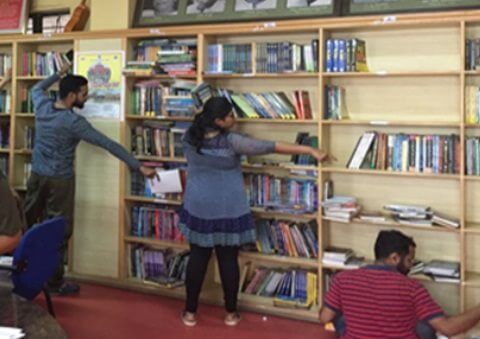 people putting books up in a library