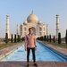 man in pink shirt standing in front of the Taj Mahal