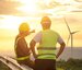 2 male construction workers pointing to and discussing the wind farm