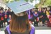 woman wearing graduate hat facing towards graduate peers