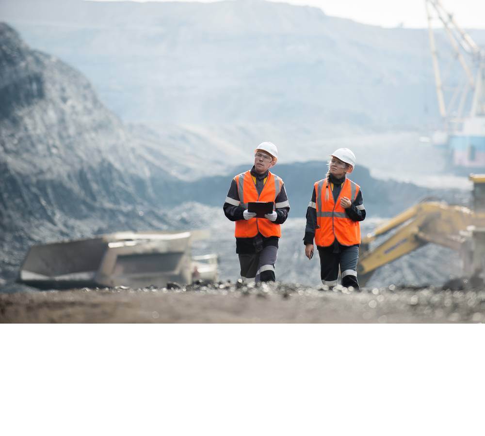 people walking in high visibility jacket through construction site