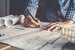 Concept architects, engineer holding pen pointing equipment architects On the desk with a blueprint in the office, Vintage, Sunset light.Selective Focus