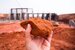 hand holding up a piece of from the ground and a construction site in the background