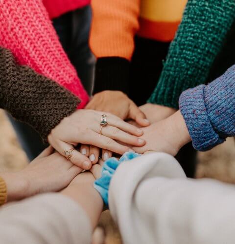 image of people putting their hands together