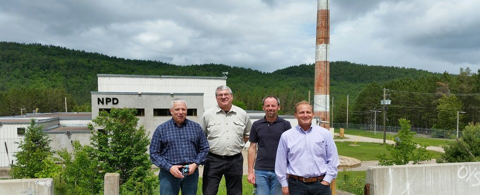 four men standing in front of a building