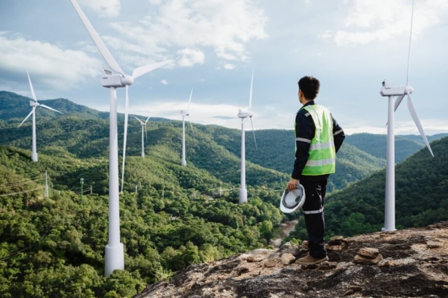 Young maintenance engineer man working in wind turbine on the mountain,Power generation Saving and using renewable energy concept.