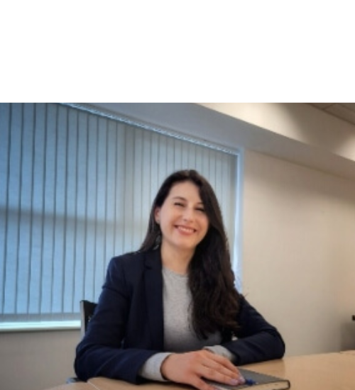 girl sat at desk wearing suit smiling