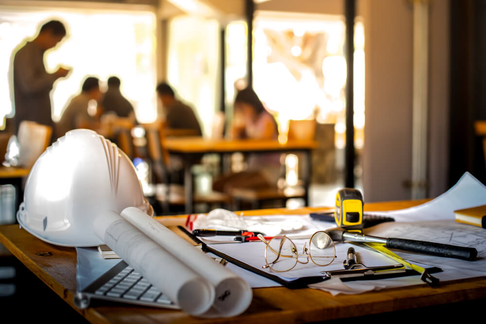 image of construction plans on a desk along with safety equipment