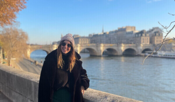 Emily leaning against a wall smiling 