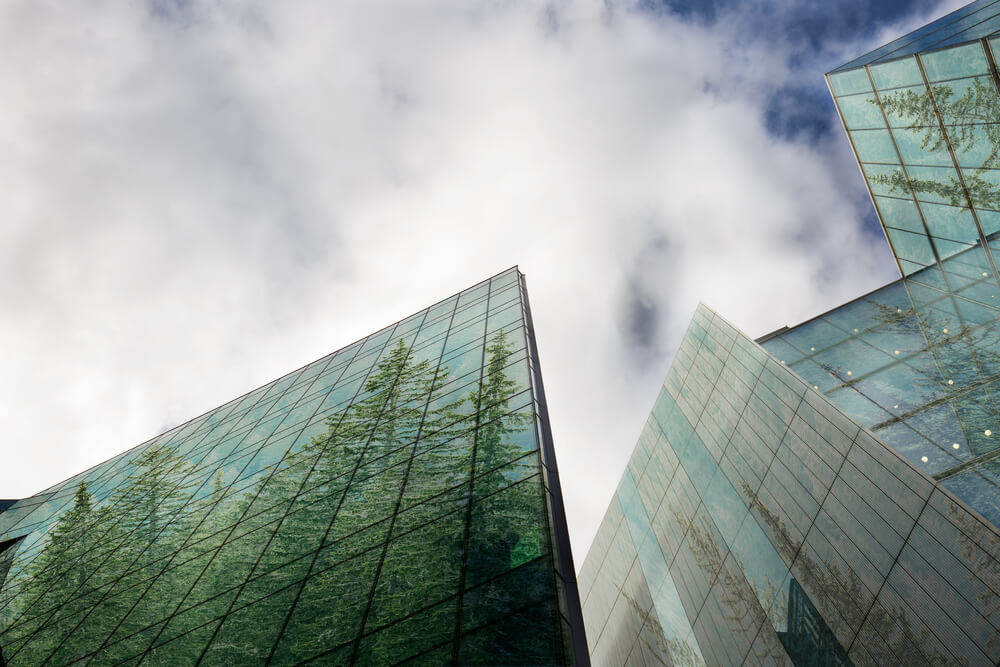 image of a building with the reflection being of trees