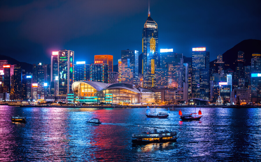 Hong Kong skyline at night with body of water and one boat