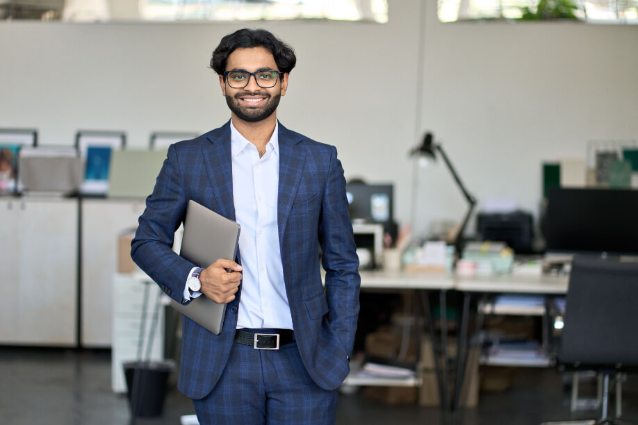 engineer holding paperwork in office and smiling