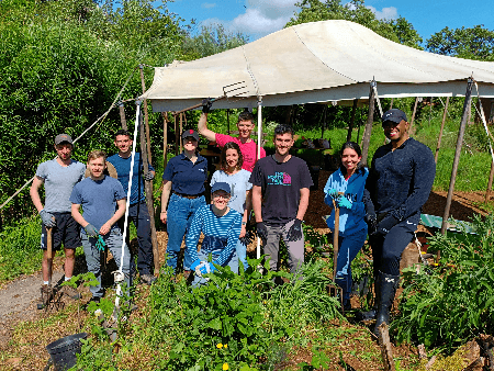 Photo of Clara with colleagues surrounded by plants