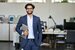 engineer holding laptop and smiling inside an office