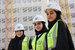 Three female engineers stoof together in hard hats and high vis jackets