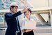 Engineer with helmet pointing into distance whilst smiling with intern engineer holding laptop