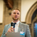 A photo of Jason speaking into a microphone
