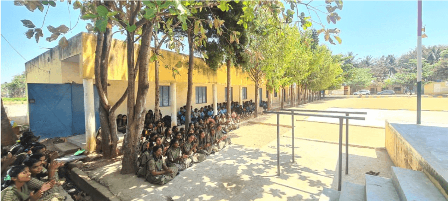 Indian school children sitting on the floor for assembly