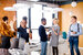 Diverse group of graduates networking in the corner of a room at a careers fair