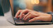 hands typing on a laptop