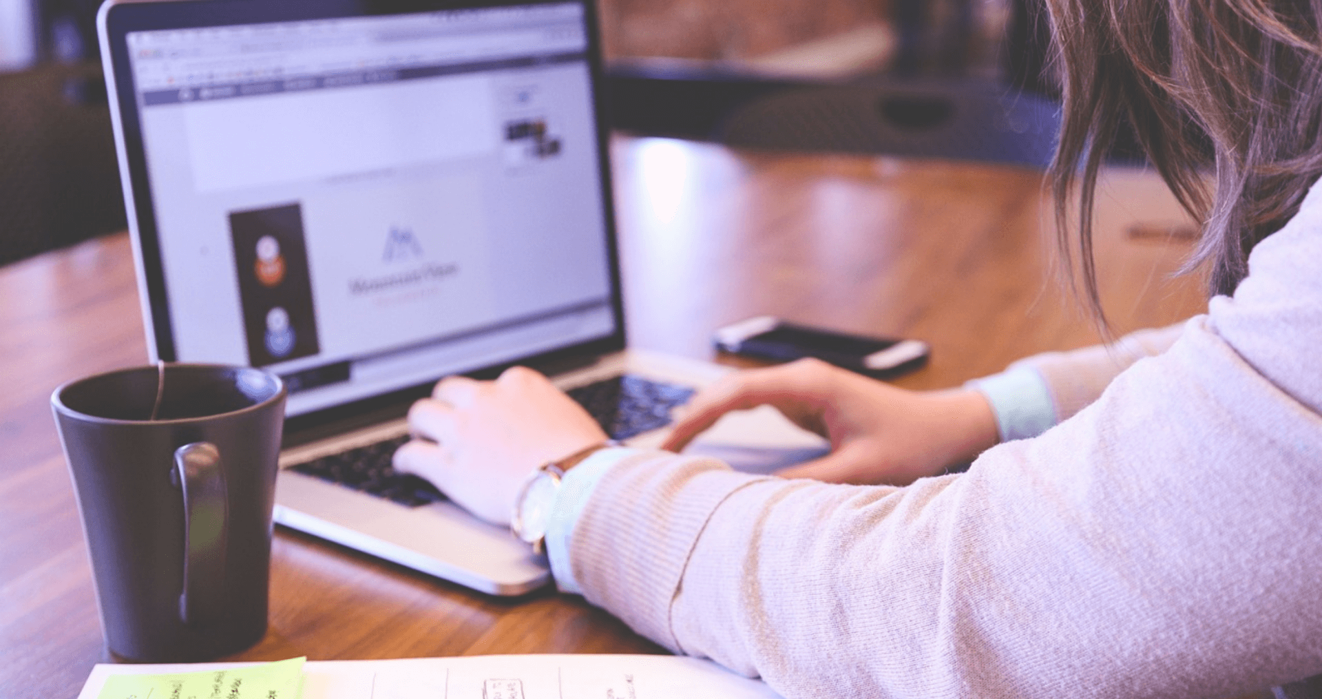 Person sitting at their desk working on laptop