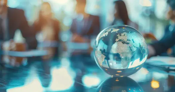 People sitting around a globe promoting TRS Workforce Solutions as Global