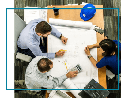 People sitting around a desk reviewing plans