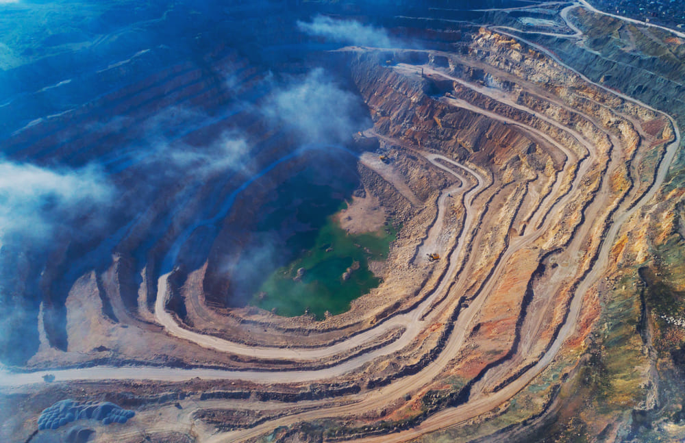 Aerial view of opencast mining quarry with lots of machinery at work - view from above