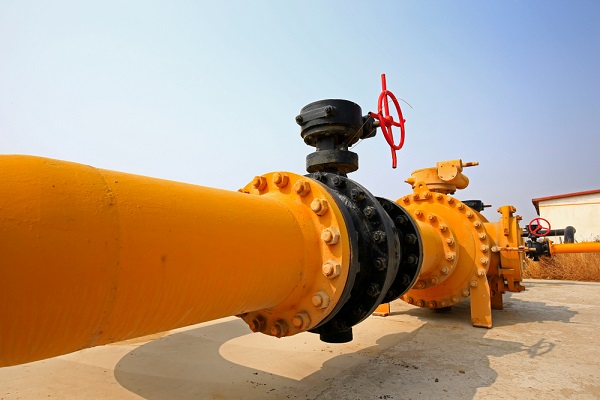 An orange oil/gas pipeline in a desert.