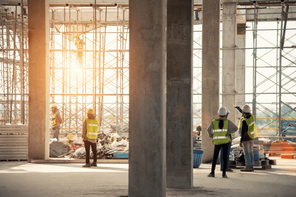 Group of construction engineer team in standard safety uniform work planing in construction site, supplied by construction staffing agency