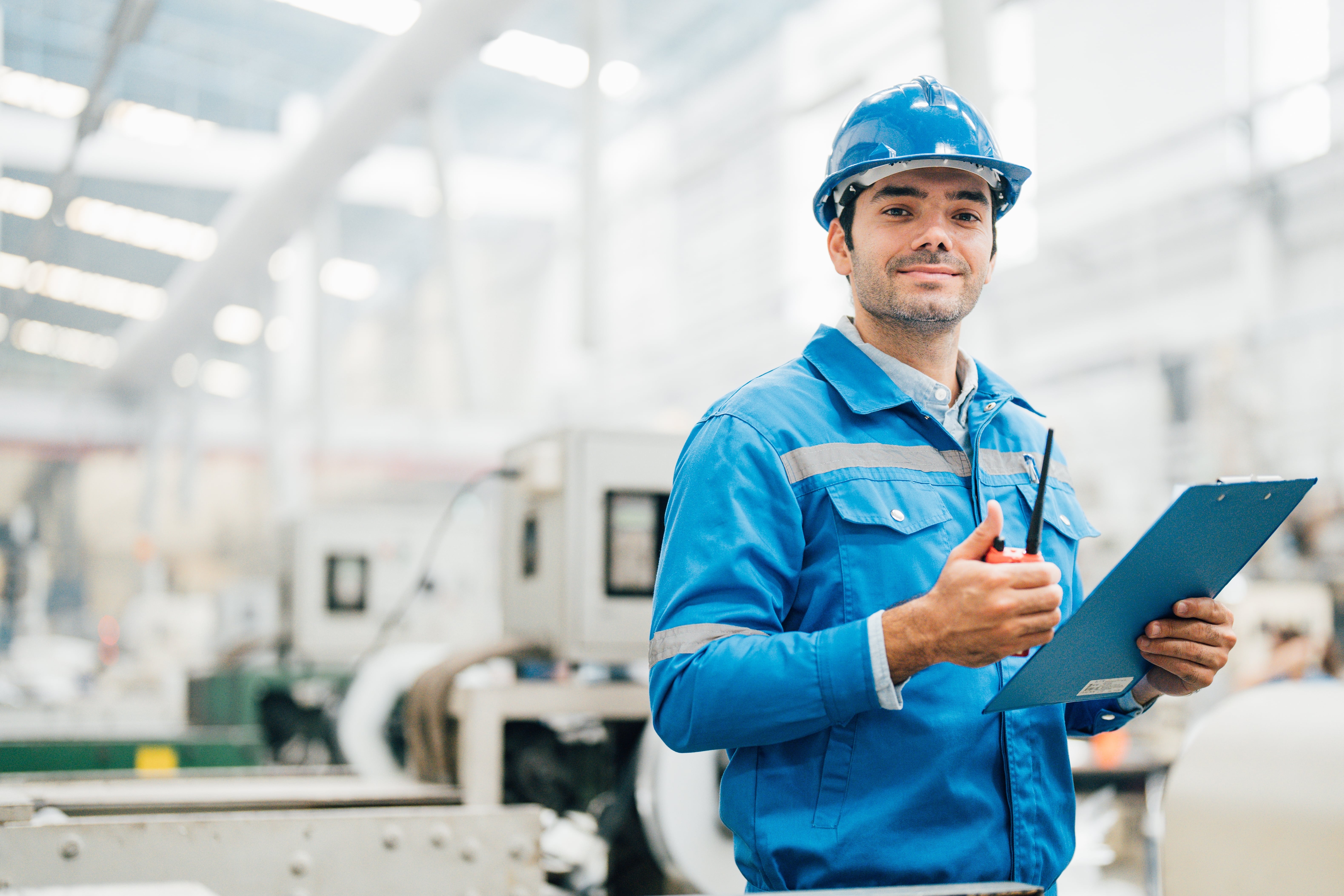 mechanical engineer wearing a blue high vis and holding a clipboard.