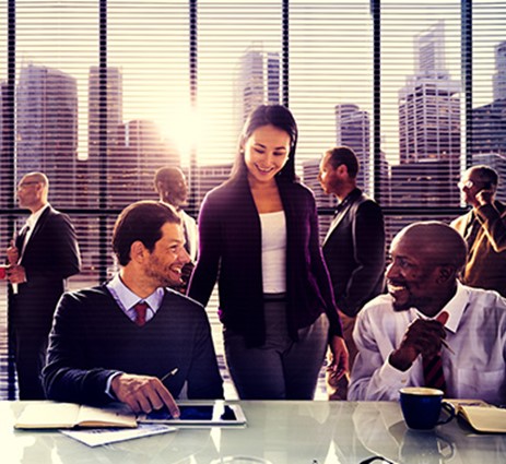 People in an office environment at a desk with a tablet.