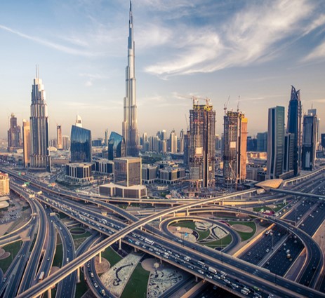 A city image from the sky with road networks, skyscrapers, and the sky in the background.