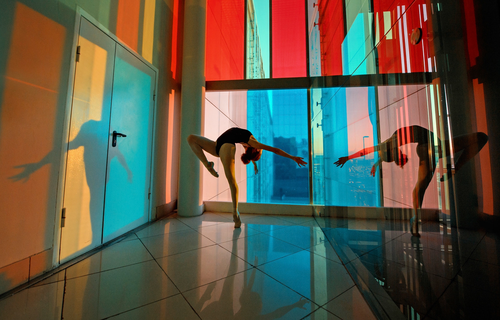 Dancing ballerina in front of glass window