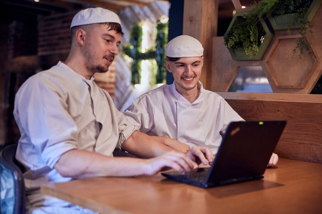 two kitchen managers looking at a computer 