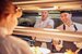 two men and one woman working in a kitchen in their chef whites and smiling