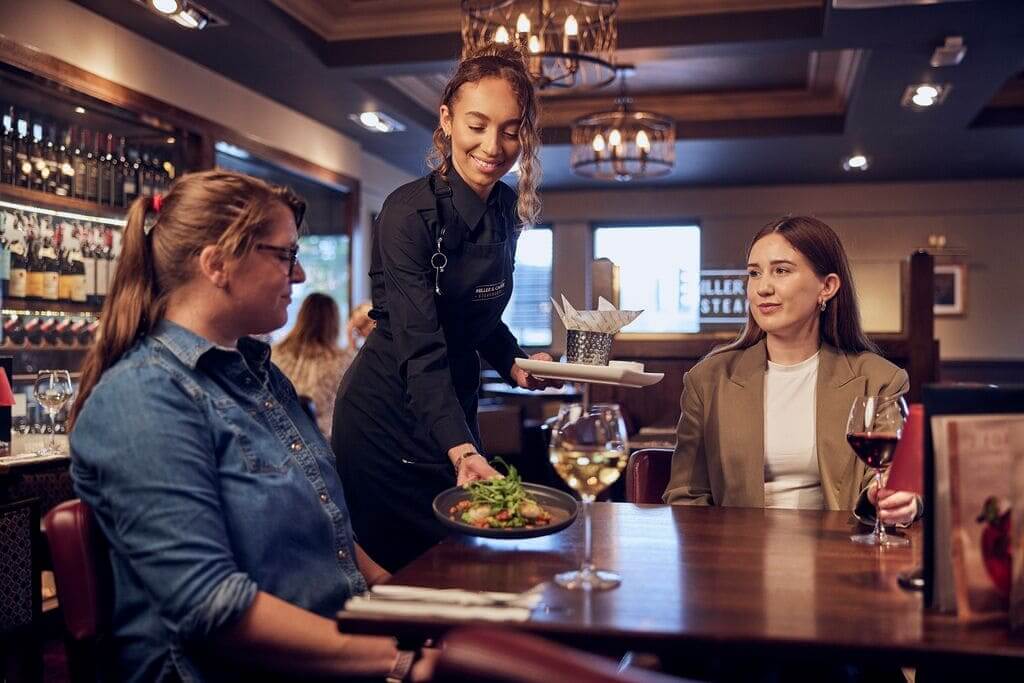 bar and waiting apprenticeship serving guests with a smile
